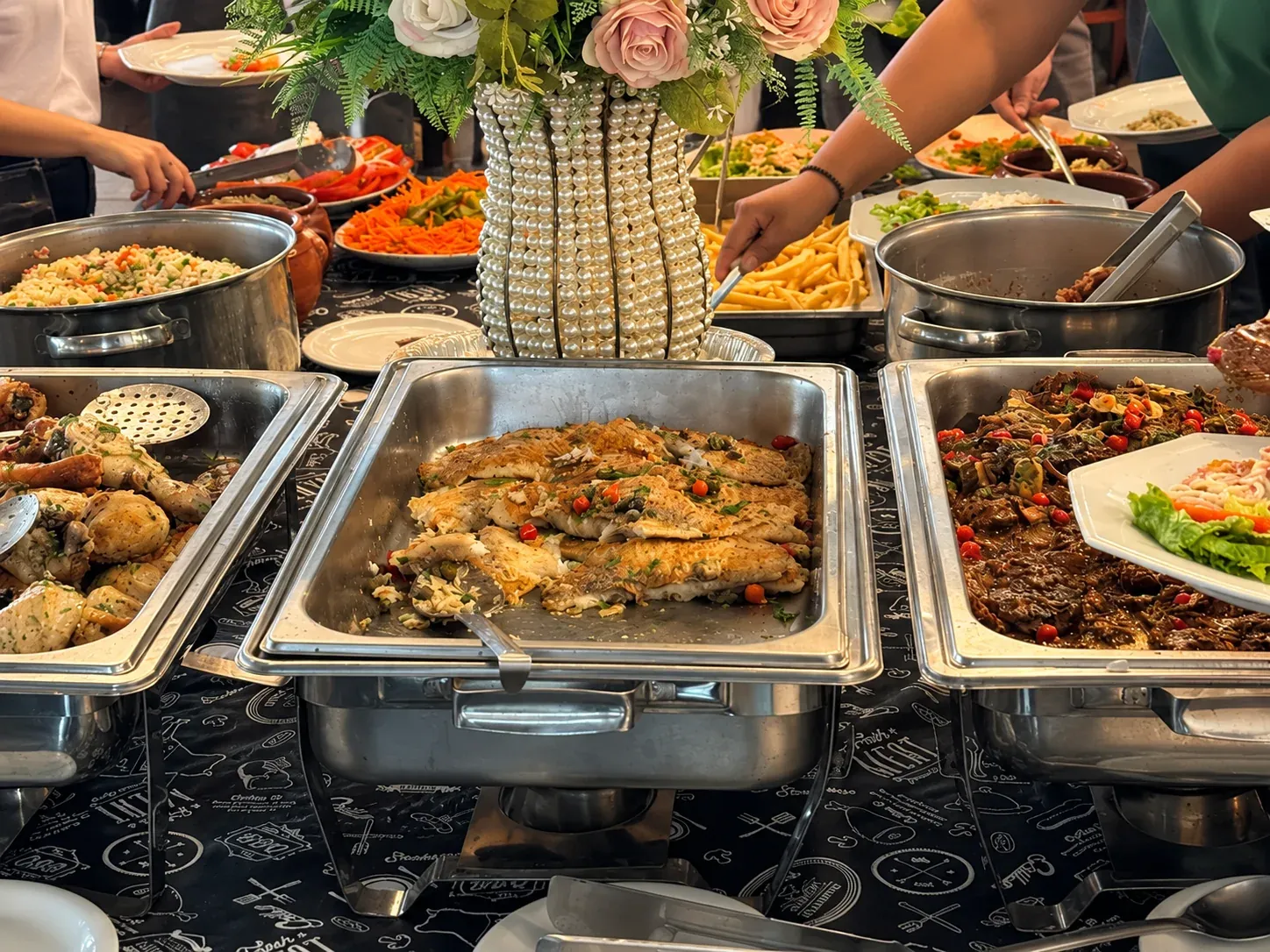Buffet do evento com pratos variados e arranjo de flores